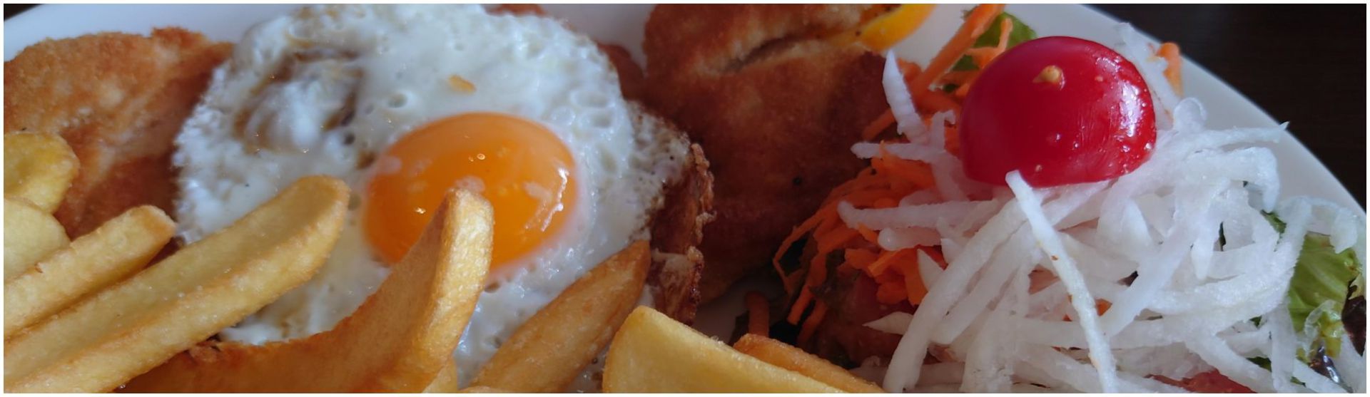 Haehnchenschnitzel Hamburger Art an Pommes mit Salat